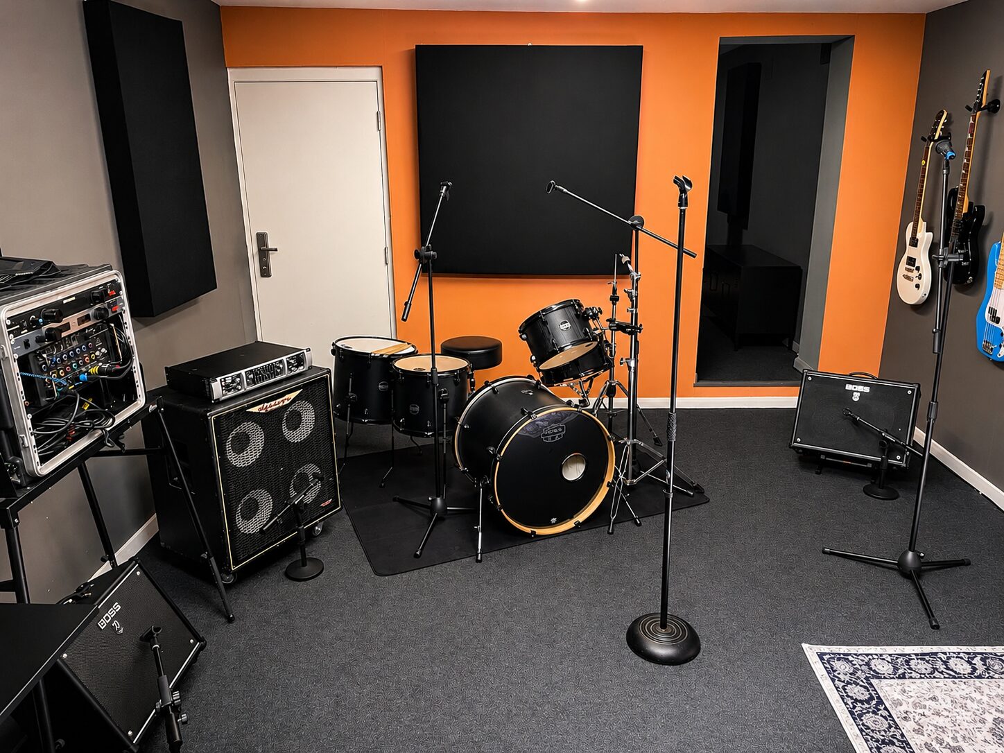 Live room with drum kit, amps and guitars set up ready for a session
