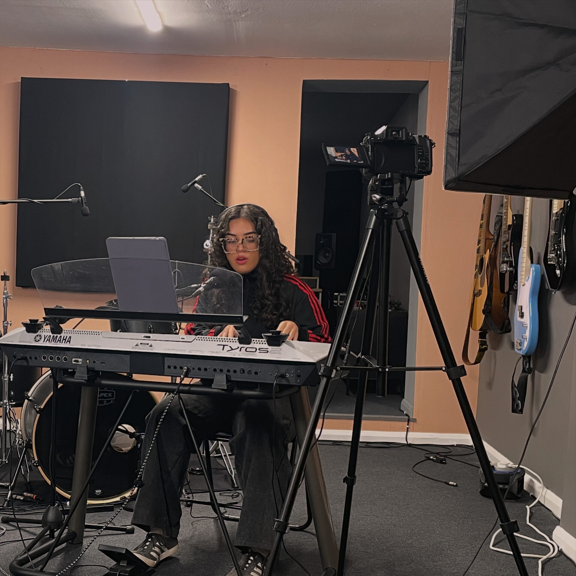 Artist recording keys on stage piano while being filmed