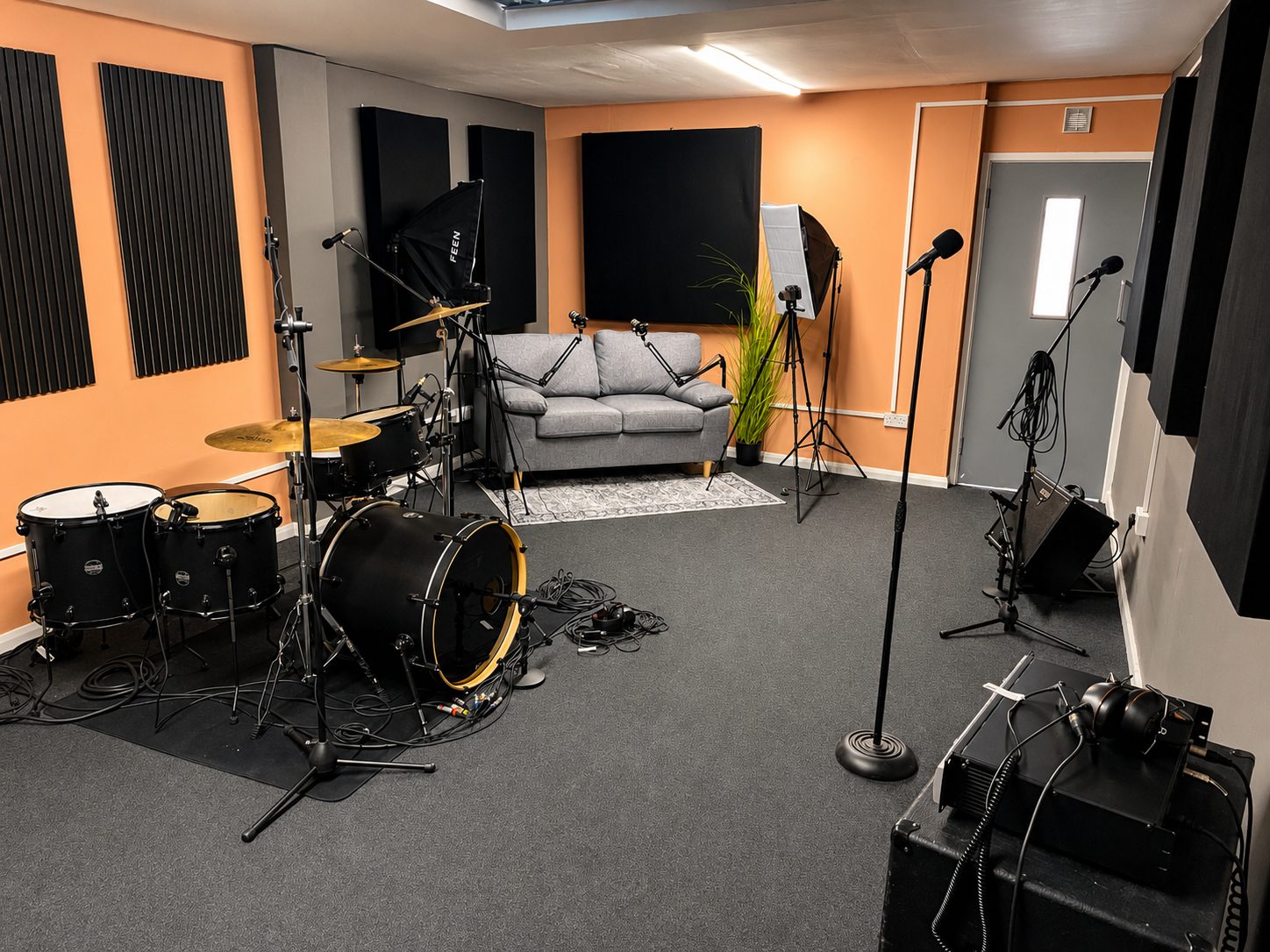 Live room set up with drum kit, microphones and seating area